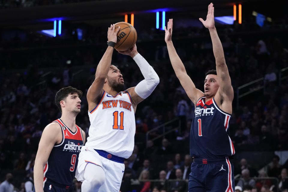 New York Knicks' Jalen Brunson (11) shoots over Washington Wizards' Johnny Davis (1) and Deni Avdija (9) during the first half of an NBA basketball game Sunday, April 2, 2023, in New York. (AP Photo/Frank Franklin II)