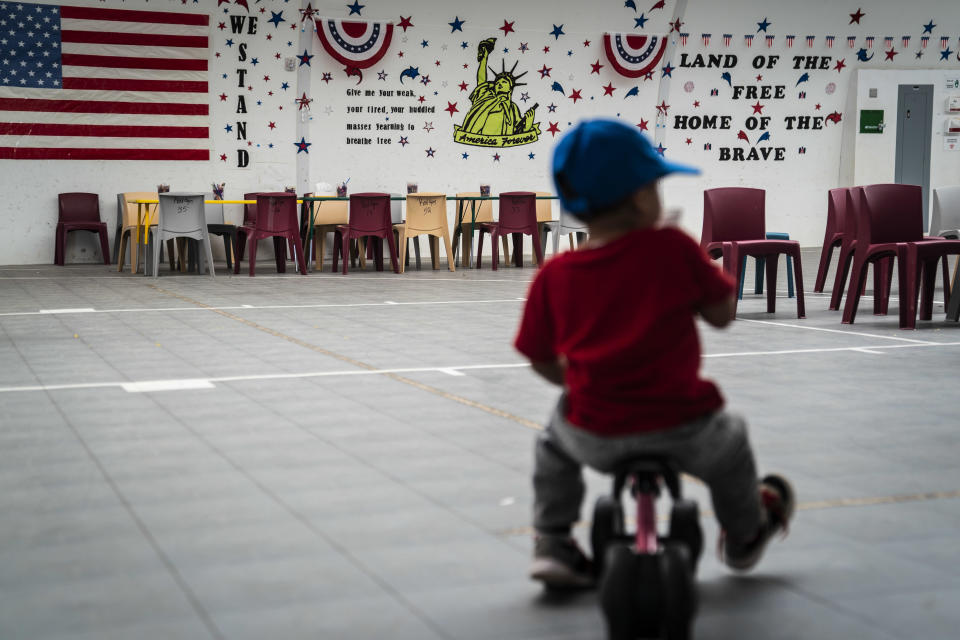An immigrant child plays in front of patriotic phrases and symbols covering the walls in a gymnasium as U.S. Immigration and Customs Enforcement (ICE) and Enforcement and Removal Operations (ERO) hosts a media tour at the South Texas Family Residential Center. / Credit: The Washington Post