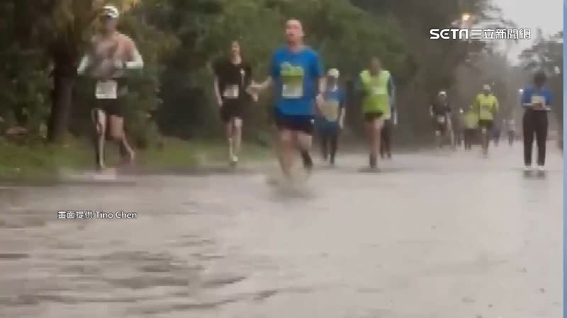 桃園舉辦海風馬拉松遇上狂風暴雨，跑者們在積水的路面上路跑。（圖／Tino Chen提供）