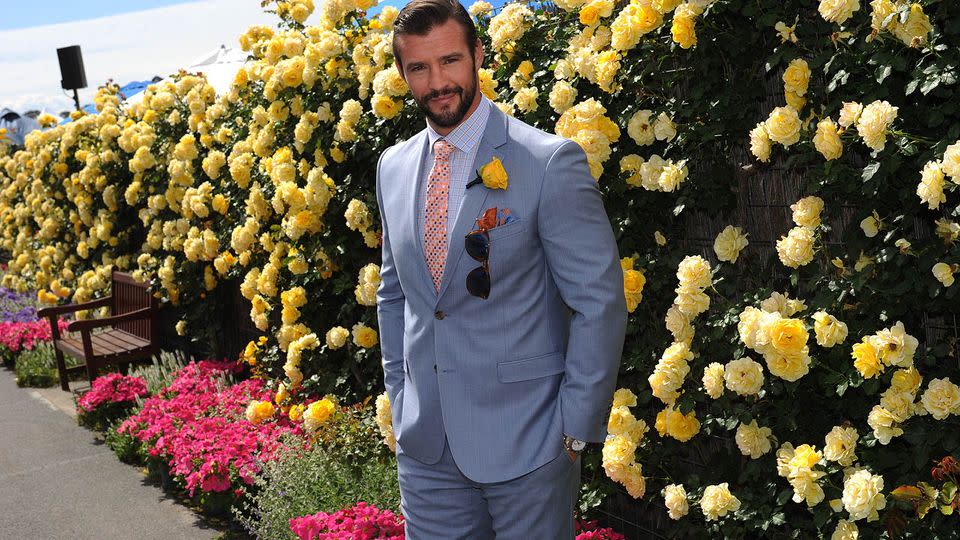 Kris looking resplendent next to a wall of yellow flowers. Source: AAP