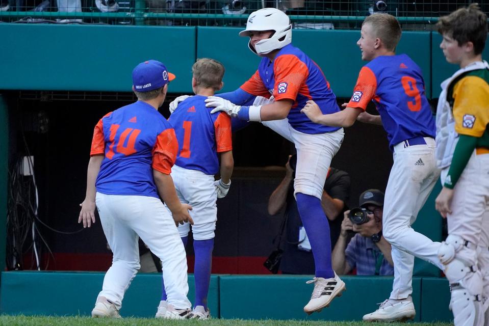 Hagerstown, Ind.'s Preston Allred (1) celebrates with teammates after scoring the winning run on a ball hit  by Kaden Hall, as Davenport, Iowa's Theodore Swanson, right, watches during the bottom of the sixth inning of a baseball game at the Little League World Series in South Williamsport, Pa., Thursday, Aug. 18, 2022. Indiana won 8-7.