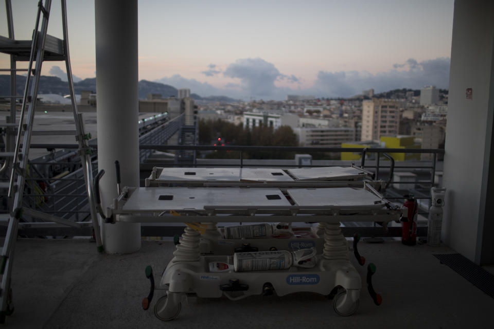 Portable intensive care beds with oxygen tanks are pictured on the rooftop of the La Timone hospital as the sun rises in Marseille, southern France, Friday, Nov. 13, 2020. France is more than two weeks into its second coronavirus lockdown, and intensive care wards have been over 95% capacity for more than 10 days now. Marseille has been submerged with coronavirus cases since September. (AP Photo/Daniel Cole)