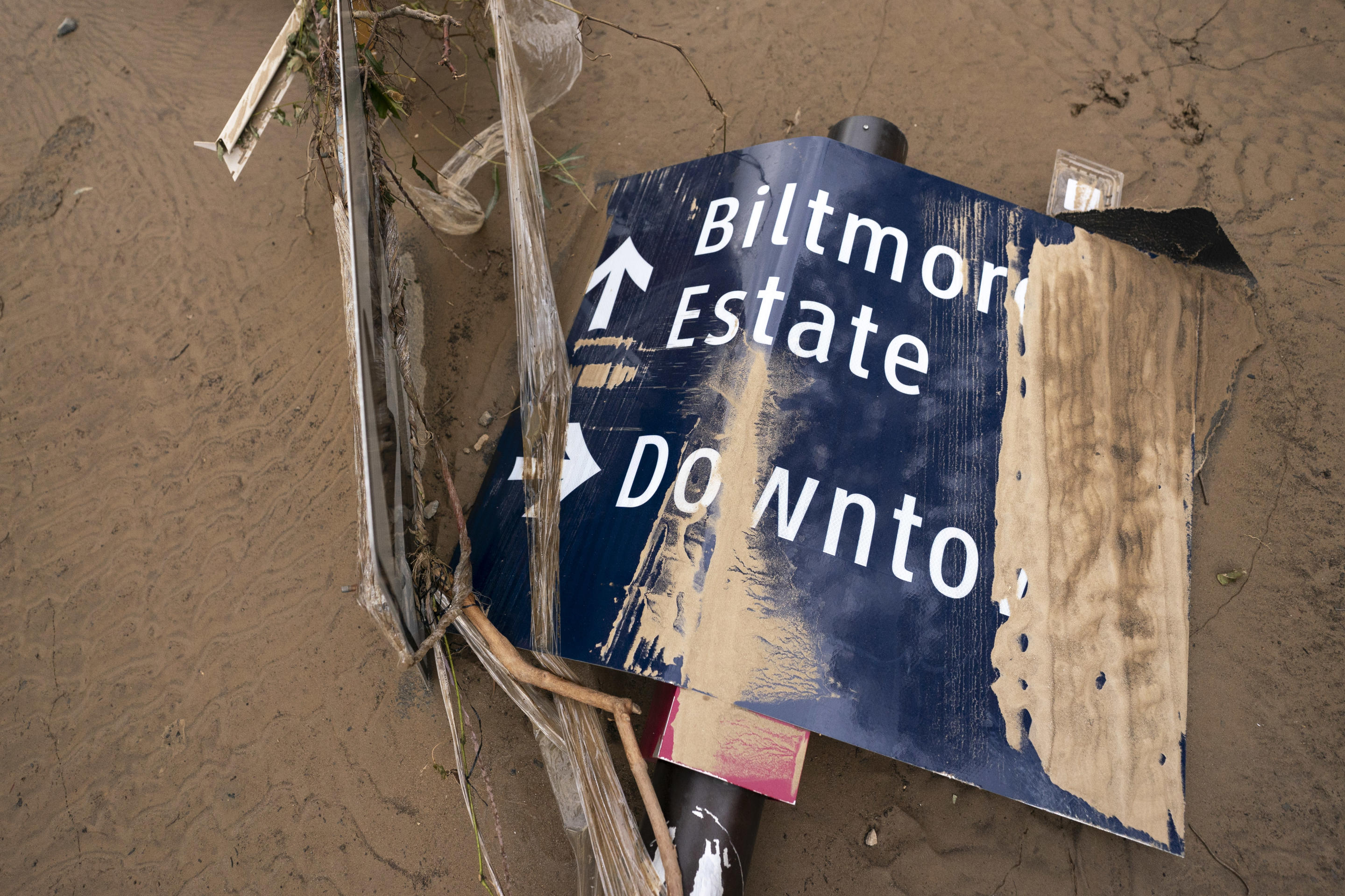 A damaged sign amidst rubble.