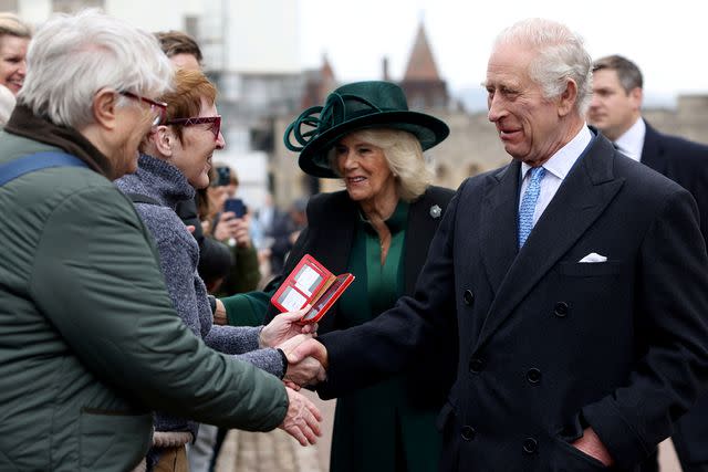 <p>Hollie Adams - WPA Pool/Getty Images</p> Queen Camilla (center) and King Charles (right) greet people after attending the Easter church service at St. George's Chapel on March 31, 2024
