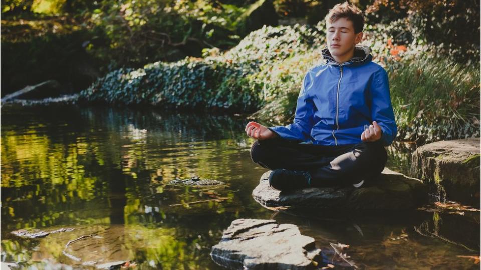 Un adolescente practica meditación mindfulness.