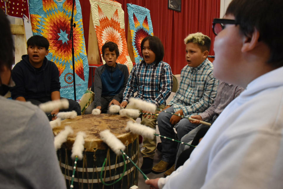 FILE -Students from Rosebud Elementary School perform in a drum circle during a meeting about abusive conditions at Native American boarding schools at Sinte Gleska University on the Rosebud Sioux Reservation in Mission, S.D., Saturday, Oct. 15, 2022. Federal officials have been holding listening sessions as part of a nationwide tour to confront the legacy of the government-backed schools. (AP Photo/Matthew Brown, File)