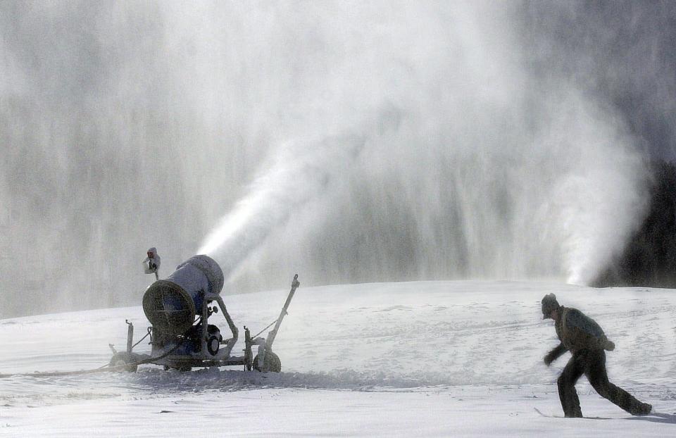 Greek Peak Ski Resort snowmaker John Murphy trudges through ankle deep artificial snow as he checks snowmaking machines on the Virgil, N.Y., resort's Alpha Slope, in 2000.