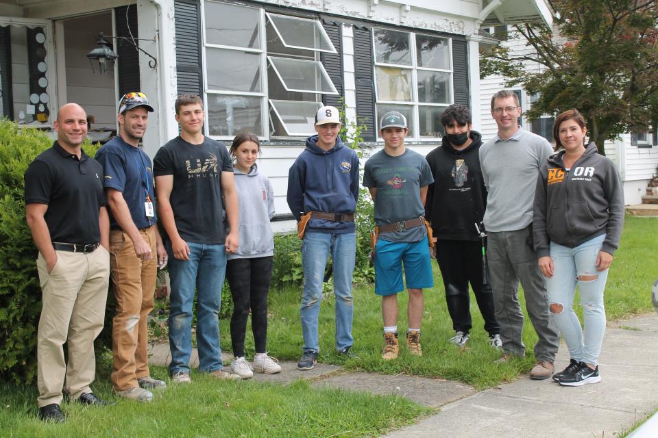 Posing for a photo outside the Bound Brook home where the critical repairs were taking place are (\left to right) SCVTHS Supervisor of Career and Technical Education Rob Carrig, SCVTHS Cooperative Education Coordinator Gerald Mazzetta, SCVTHS students Ryan Oset of Manville, Emily Granja of Bridgewater, Steven LaRosa of Bridgewater, Will Rogus of Branchburg, Armando Garcia of Bridgewater, SCVTHS Carpentry Instructor James Foley, and Community Services Manager for Raritan Valley Habitat for Humanity Jessica Mauceri.