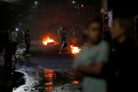 People are seen next to barricades along a street at a protest during curfew while the country is still mired in chaos over a contested presidential election in Tegucigalpa, Honduras December 3, 2017. REUTERS/Henry Romero