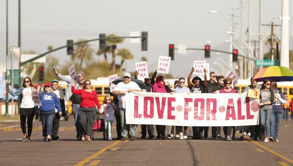 People march with a "Love for All" banner during the MLK Day Parade in Mesa, Ariz., on Jan. 21, 2019.