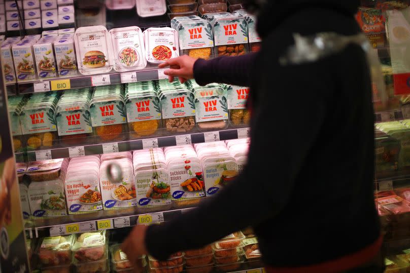 A store clerk shows plant based products at a supermarket chain in Brussels, October 2020