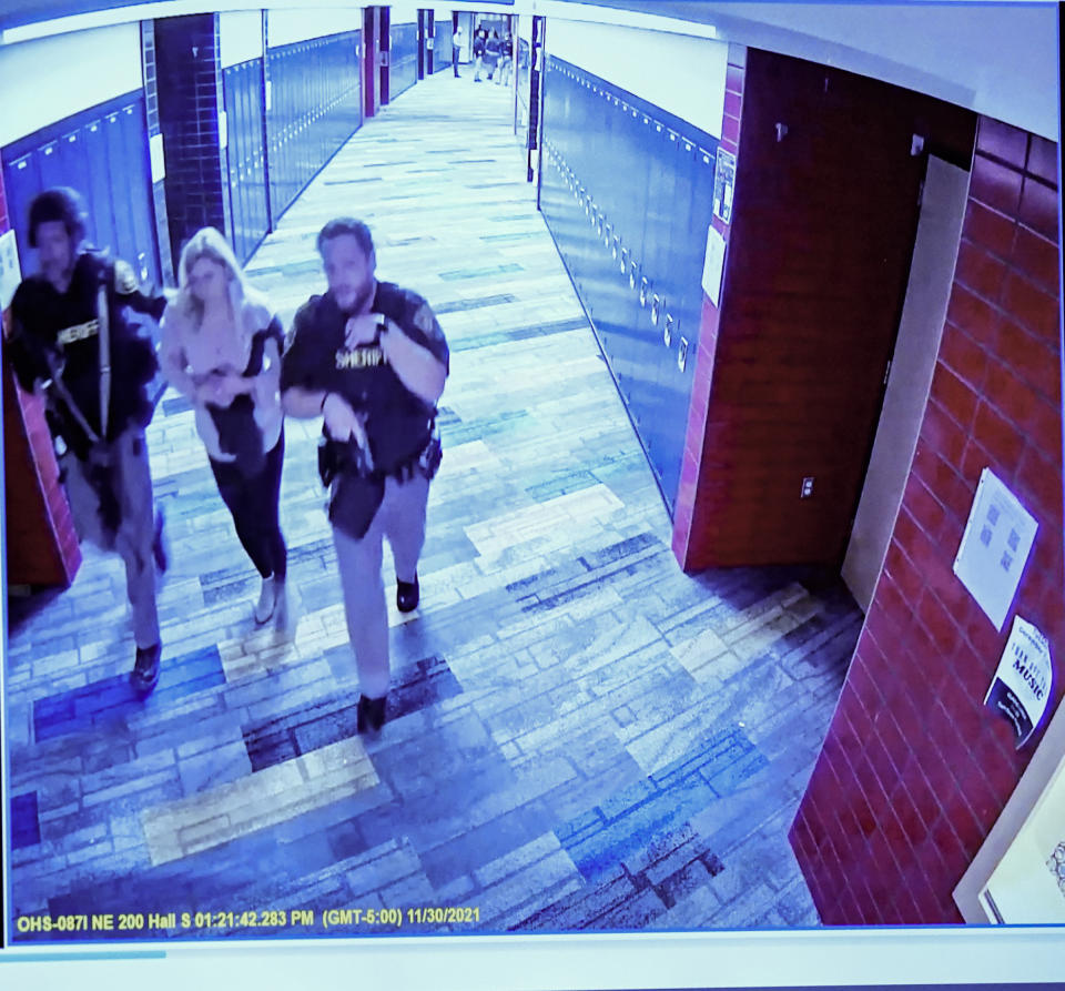 Security footage is shown to the jury of sheriff's deputies escorting Molly Darnell out of Oxford High school after she sustained a gunshot wound on Nov. 30, 2021 during the trial of James Crumbley on Thursday, March. 7, 2024 in Pontiac, Mich. James Crumbley, 47, is charged with four counts of involuntary manslaughter, one for each teenager killed by Ethan Crumbley at Oxford High School in 2021. (Mandi Wright/Detroit Free Press via AP, Pool)