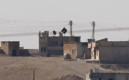 A black flag belonging to the Islamic State is seen in the Syrian town of Kobani, as pictured from the Turkish-Syrian border near the southeastern town of Suruc October 9, 2014. REUTERS/Umit Bektas