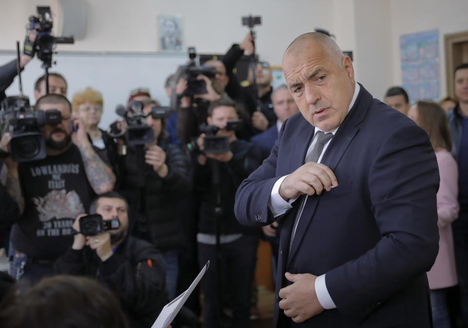 Bulgarian former Prime Minister Boiko Borisov, leader of the center-right GERB party, reaches for his national identification card upon arriving at a voting station in Sofia, Bulgaria, Sunday, March 26, 2017. Bulgarians are heading to the polls for the third time in four years in a snap vote that could tilt the European Union's poorest member country closer to Russia as surveys put the GERB party neck-and-neck with the Socialist Party. (AP Photo/Vadim Ghirda)