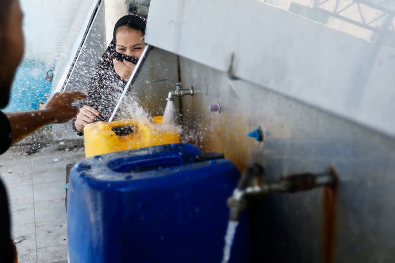 Palestinians gather to fill containers with water in the southern Gaza Strip