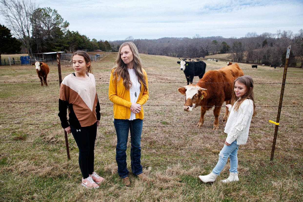 Megan Heichelbech stands in front of her cattle field with her two children Makayla (right) and Katelyn in Culleoka, Tenn. on Jan. 24, 2023. Recently Megan wrote and self published a book to help those who are overcoming Postural Orthostatic Tachycardia Syndrome (POTS) as a result contracting COVID-19.