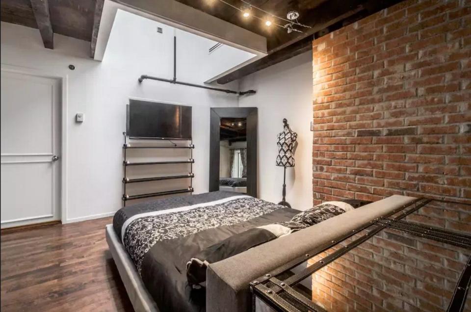 <p>The master bedroom features a queen-sized bed and exposed brick. (Airbnb) </p>