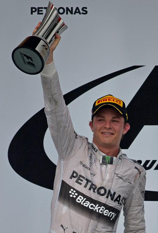 Nico Rosberg lifts up the second-place trophy at the Malaysian Grand Prix in Sepang on March 30, 2014