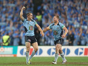 Mitchell Pearce and Trent Merrin celebrate as the full-time siren sounds.