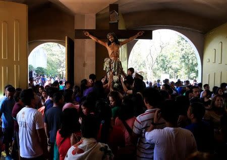 Filipino churchgoers pray in front of a Jesus Christ crucifixion statue after Rev. F. Carlos Ronquillo (not in photo), a Rector Superior of the National Shrine of Our Mother of Perpetual Help, talked about a pastoral letter from the Catholic Bishops' Conference of the Philippines (CBCP) about the drug war of President Rodrigo Duterte during a mass at the Redemptorist church in Paranaque city, metro Manila, Philippines February 5, 2017. REUTERS/Romeo Ranoco TPX IMAGES OF THE DAY