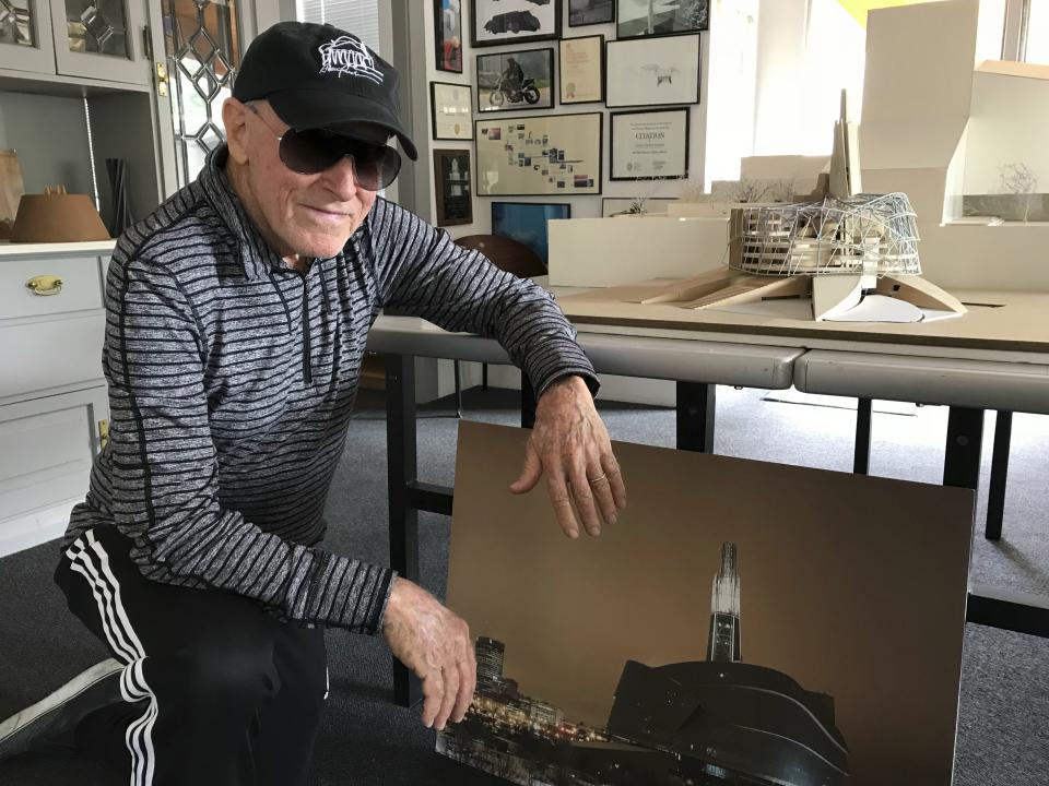 Renowned architect Antoine Predock kneels next to a model of the Canadian Museum for Human Rights in his studio in Albuquerque, N.M., April 30, 2018. Predock, whose list of credits includes award-winning buildings around the world, died Saturday, March 2, 2024, at his home in Albuquerque, according to longtime friends and colleagues. He was 87. (AP Photo/Susan Montoya Bryan)