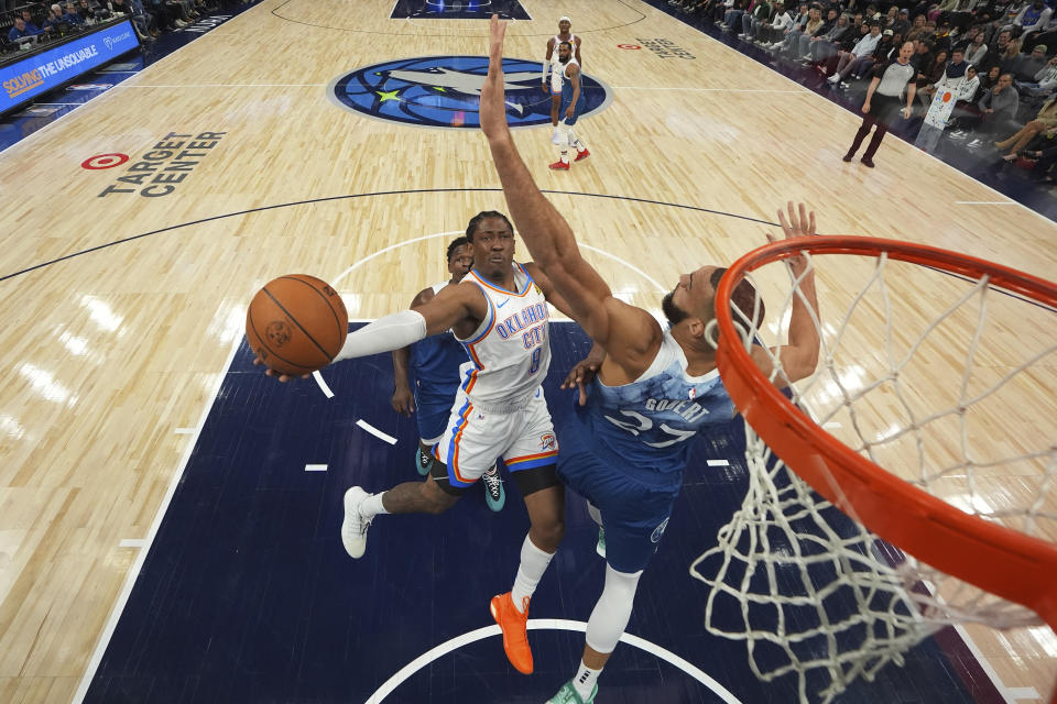 Oklahoma City Thunder forward Jalen Williams (8) goes up for a shot as Minnesota Timberwolves center Rudy Gobert (27) defends during the first half of an NBA basketball game Saturday, Jan. 20, 2024, in Minneapolis. (AP Photo/Abbie Parr)