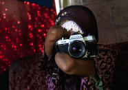 Armless professional photographer Rusidah, 44, takes a photograph as she carries out camera maintenance on March 13, 2012 in Purworejo, Indonesia. (Photo by Ulet Ifansasti/Getty Images)