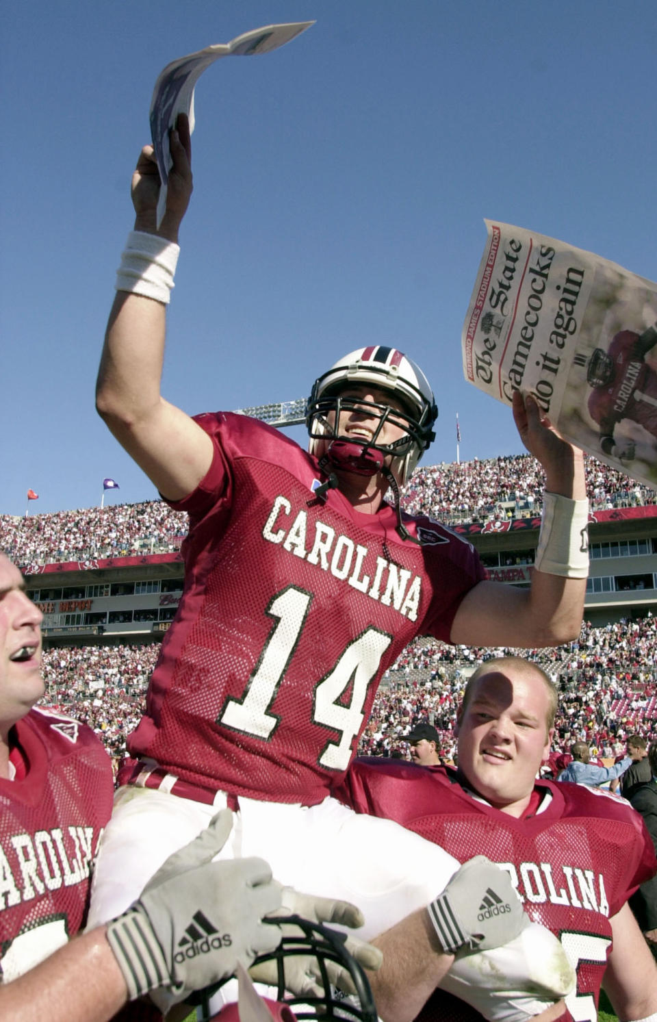 FILE - South Carolina quarterback Phil Petty (14) gets carried off the field by teammates after defeating Ohio State 31-28 on Tuesday, Jan. 1, 2002, in the Outback Bowl in Tampa, Fla. Petty, the former South Carolina quarterback who led Lou Holtz's teams to two Outback Bowl wins has died at age 43. The school announced Petty's death on Thursday, July 21, 2022. (AP Photo/Chris O'Meara, File)