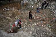 Forensic experts inspect part of a mass grave site in the village of Rudnica, 280 kilometers (170 miles) south of Belgrade, Serbia, Wednesday, April 23, 2014, wehre at least 250 bodies of ethnic Albanian victims of the 1998 - 99 Kosovo war are believed to be buried. Some 10,000 people were killed during the conflict between Serbian security troops and Kosovo separatists, and The Serbian government official dealing with the wartime missing, Veljko Odalovic, said Wednesday that the exhumation in the village of Rudnica, will take about 60 days. (AP Photo/Darko Vojinovic)