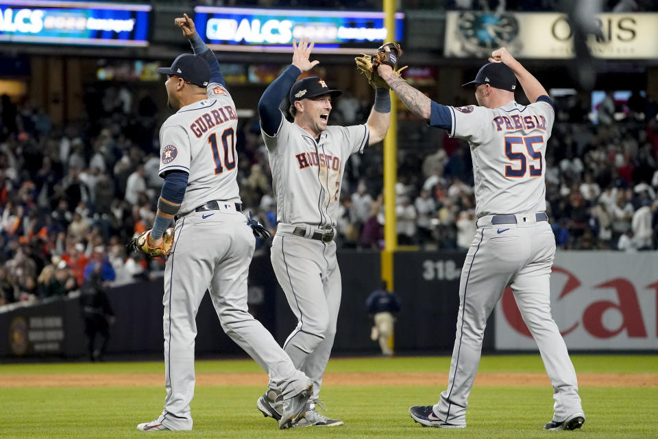 Houston Astros first baseman Yuli Gurriel, Alex Bregman and relief pitcher Ryan Pressly (55) celebrate after the Astros defeated the New York Yankees 6-5 to win Game 4 and the American League Championship baseball series, Monday, Oct. 24, 2022, in New York. (AP Photo/John Minchillo)