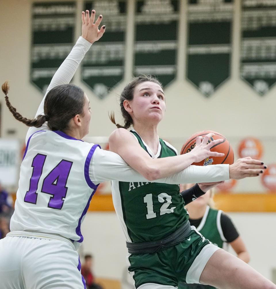 Pendleton Heights Arabians guard Kaycie Warfel (12) goes in for a lay-up against Muncie Central Bearcats Katie White (14) on Wednesday, Jan. 31, 2024, during the game at Pendleton Heights High School in Pendleton.