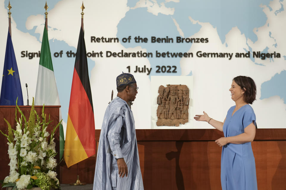 German Foreign Minister Annalena Baerbock, right, and the Minister of Information and Culture of Nigeria Lai Mohammed pose for media in front of two Benin Bronze sculptures after signing an agreement in Berlin, Germany, Friday, July 1, 2022. Germany and Nigeria signed an agreement in Berlin Friday paving the way for the return of centuries-old sculptures known as the Benin Bronzes that were taken from Africa in the 19th century and displayed in German museums and elsewhere. (AP Photo/Markus Schreiber)