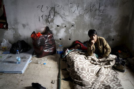 Afghan refugees rest in an old abandoned beach house as they wait to board a dinghy sailing off for the Greek island of Chios, while they try to travel from the western Turkish coastal town of Cesme, in Izmir province, Turkey, March 6, 2016. REUTERS/Umit Bektas