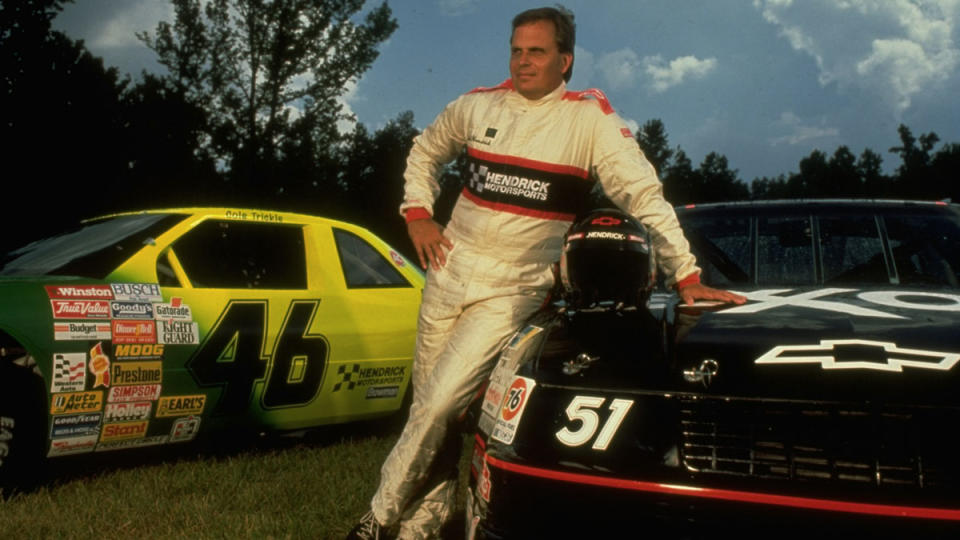 Rick Hendrick stands between two of his cars that appeared in the film "Days of Thunder."