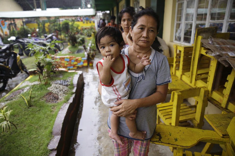 Evacuees walk inside an evacuation center as rains from Typhoon Mangkhut begin to affect Tuguegarao city, Cagayan province, northeastern Philippines on Friday, Sept. 14, 2018. Typhoon Mangkhut retained its ferocious strength and slightly shifted toward more densely populated coastal provinces on Friday as it barreled closer to the northeastern Philippines, where a massive evacuation was underway. (AP Photo/Aaron Favila)