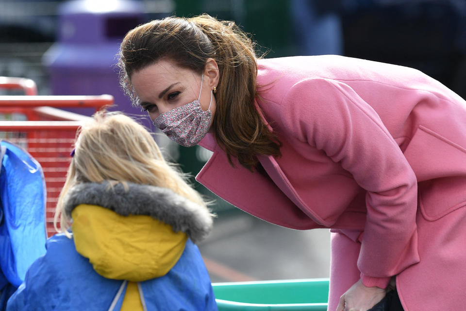 Britain's Catherine, Duchess of Cambridge interacts with a child in the water area of the playground during a visit to School21 following its re-opening after the easing of coronavirus lockdown restrictions in east London on March 11, 2021. - The visit coincides with the roll-out of Mentally Healthy Schools resources for secondary schools and how this is helping put mental health at the heart of their schools curriculum. (Photo by JUSTIN TALLIS / various sources / AFP) (Photo by JUSTIN TALLIS/AFP via Getty Images)