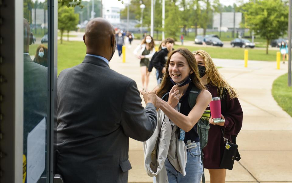 East Lansing High School Principal Andrew Wells welcomes students with a fist bump Thursday morning, May 19, 2022, as they enter the school. Every morning he greets and acknowledges each and every student as they arrive. After 33 years in education, he'll retire at the end of the academic year.