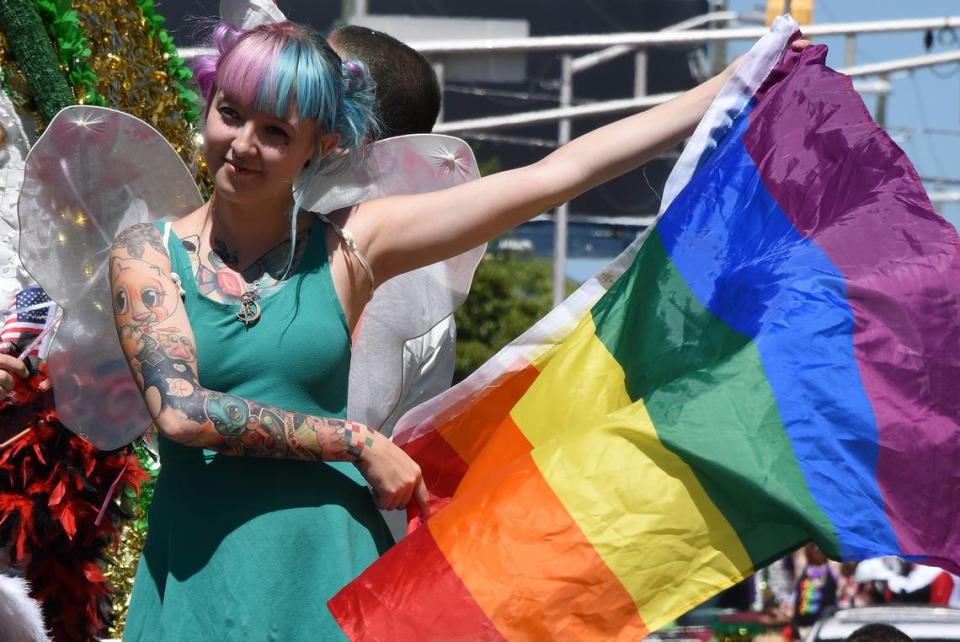 A diverse crowd of lesbian, gay, bisexual, transgendered, queer South Carolinians gather with straight allies, parents and friends to celebrate diversity during a recent South Carolina Pride Parade and Festival in Columbia. Here, Tabitha Harris waves a rainbow umbrella as she rides on the float by Mr. Shorty’s Tattoo Emporium.