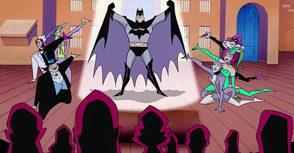 Batman on stage surrounded by his foes