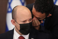 Israeli Prime Minister Naftali Bennett is spoken to as he attends a cabinet meeting at the prime minister's office in Jerusalem, Sunday, Aug. 1, 2021. (Abir Sultan/Pool Photo via AP)