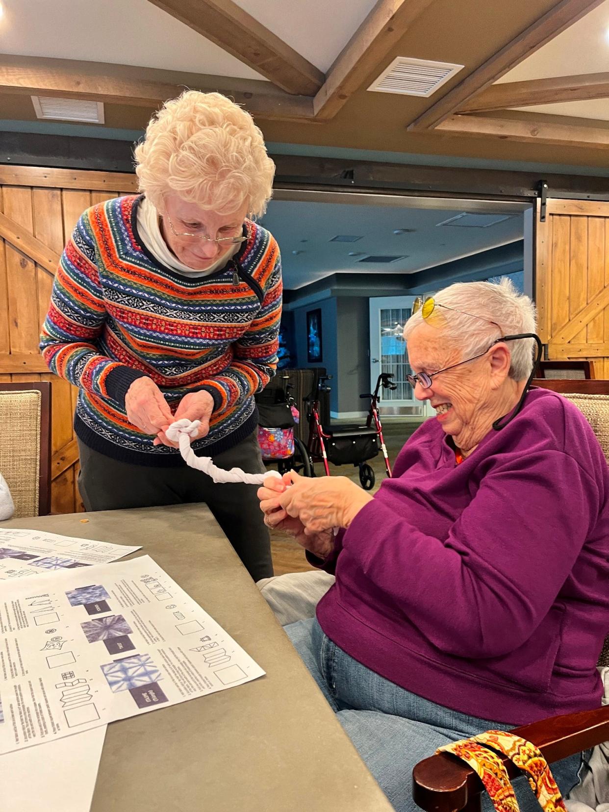 Residents Barbara O’Brien and Ellen Rosen twist the fabric to create beautiful patterns of Shibori Tie Dye.