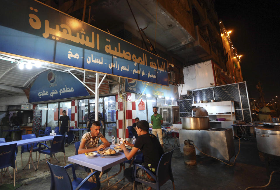 In this Sunday, Oct. 30, 2016 photo, customers eat pache at a restaurant in central Baghdad, Iraq. There are any number of delicious recipes that put the Iraqi city of Mosul on the culinary map long before it was devoured by the Islamic State group. And there is pache _ the head, intestines and other parts of animals, boiled in giant vats. (AP Photo/Hadi Mizban)