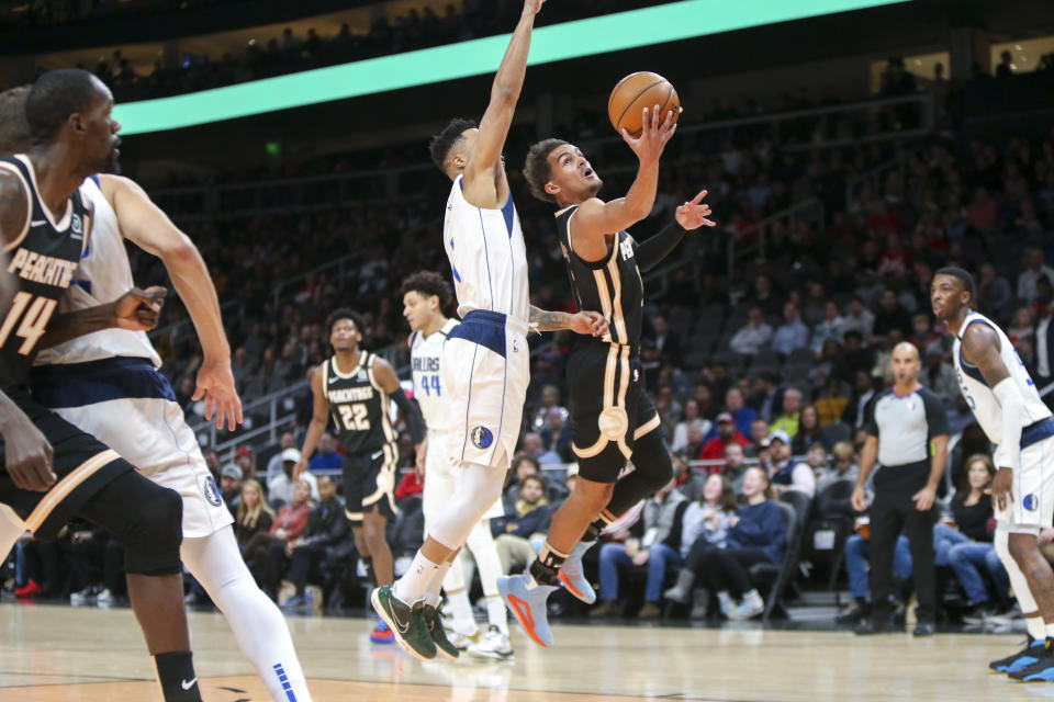 Atlanta Hawks guard Trae Young, right, shoots past Dallas Mavericks guard Courtney Lee in the first half of an NBA basketball game Saturday, Feb. 22, 2020, in Atlanta, Ga. (AP Photo/Brett Davis)