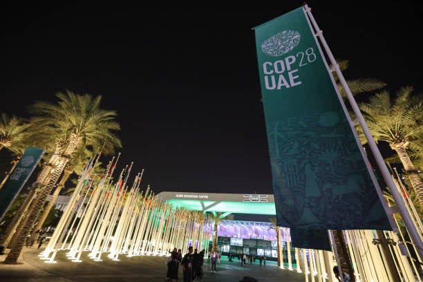 People walk outside Expo City in Dubai on 12 December 2023 during the United Nations Climate Change Conference Cop28 (AFP via Getty Images)
