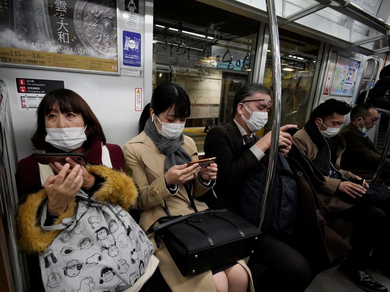 Commuters wear masks in a train in Tokyo, Japan: EPA