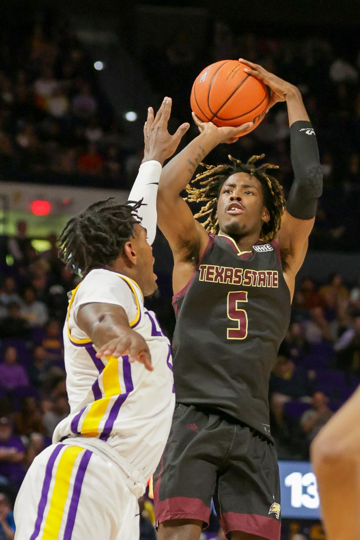 Texas State guard Caleb Asberry shoots over LSU forward Mwani Wilkinson in November. Asberry, who's from Pflugerville High School, has averaged 20 points during the Bobcats' current three-game winning streak.