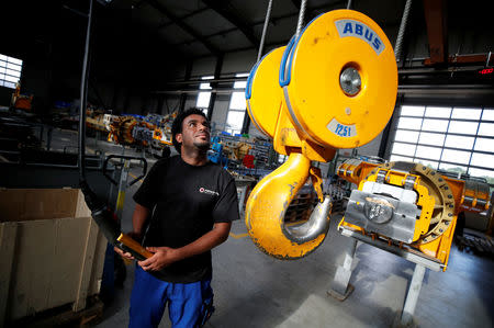 FILE PHOTO: Merhawi Tesfay, an immigrant from Eritrea poses during a Reuters interview at German plant engineering firm Kremer Machine Systems where he found a job as electrician and plant manufacturer in Gescher near Muenster, Germany, August 4, 2017. REUTERS/Wolfgang Rattay/File Photo