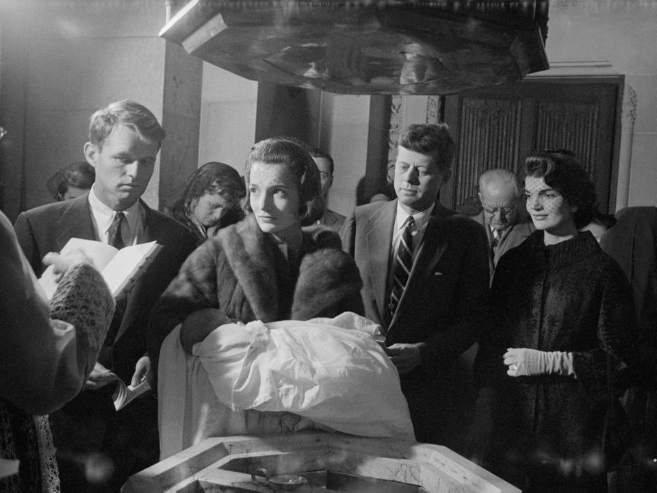 The christening of Caroline Kennedy, with Robert, John, Jackie, and Joe Sr. in the background in 1957.