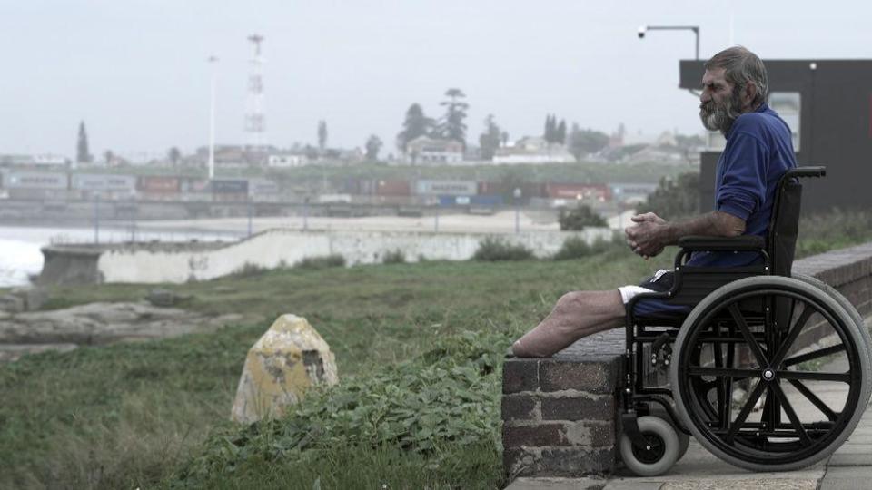 Louis van Schoor in his wheelchair looking out to the water