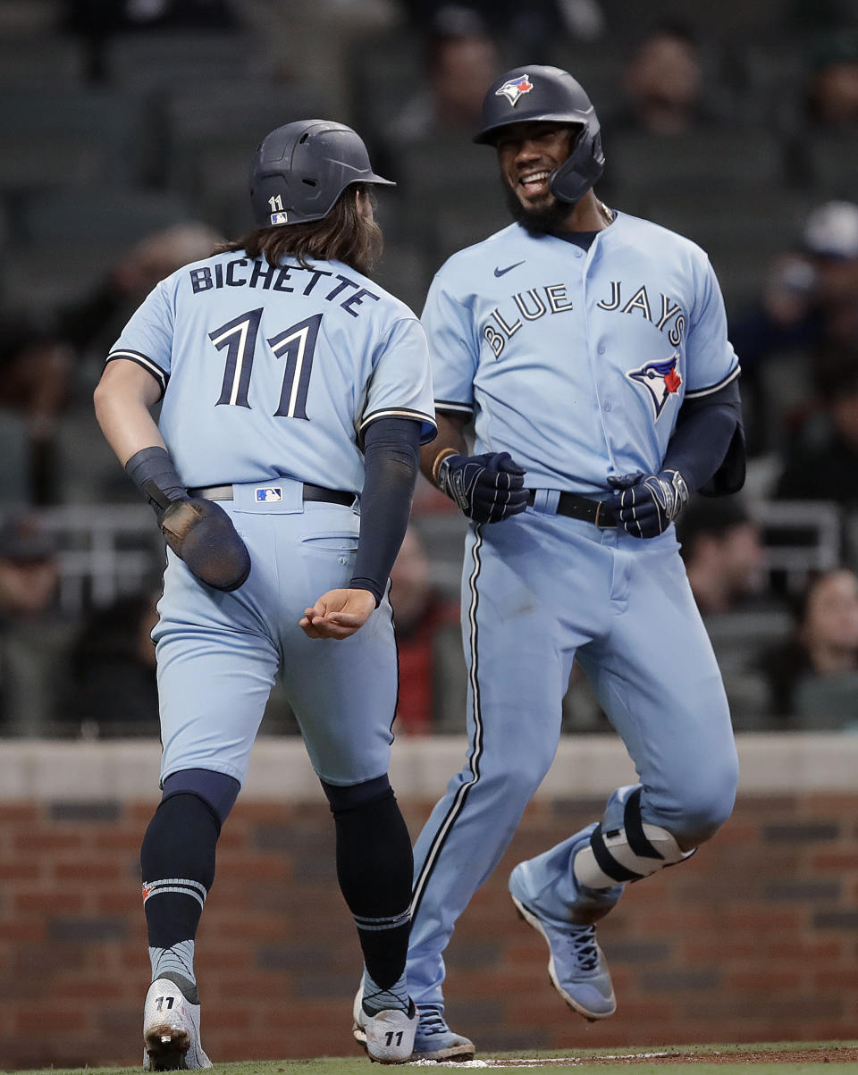 Toronto Blue Jays' Teoscar Hernandez, right, celebrates with Bo Bichette (11) after hitting a two-run home run against the Atlanta Braves during the ninth inning of a baseball game Wednesday, May 12, 2021, in Atlanta. (AP Photo/Ben Margot)